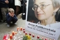 Un garçon est assis devant le portrait de Anna Politkovskaïa.（STF: DOMINIQUE FAGET / ImageForum）  