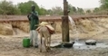 Un villageois s'approvisionne en eau（STR: FREDERIC GARLAN / ImageForum）  