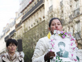 Le groupe des femmes habillées en blanc marchait en silence, tenant les photographies des pratiquants tués par le régime. (Siaoyong Sou/LGE)（攝影:  / 大紀元）  