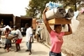 Une Haïtienne transporte du matériel distribué par une organisation d'aide humanitaire.（Staff: Chip Somodevilla / 2010 Getty Images）  