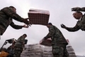 Des soldats chiliens déchargent des denrées destinées aux victimes du séisme.（Staff: EVARISTO SA / 2010 AFP）  