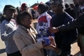 Une bénévole distribue des préservatifs à des résidents de Johannesbourg durant un match de soccer de la Coupe du monde（Staff: John Moore / 2010 Getty Images）  