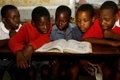 Des écoliers partagent le même manuel dans une école primaire du Zimbabwe.（Stringer: AFP / 2009 AFP）  