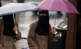 Des femmes, s’abritant sous leurs parapluies, portent le Niqab le 20 juillet 2010, à Blackburn, Angleterre (Christopher Furlong/Getty Images)（攝影:  / 大紀元）  
