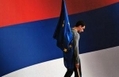 Un travailleur porte le drapeau de l’Union européenne, en marchant devant le drapeau de la nation serbe. （Stringer: ANDREJ ISAKOVIC / 2006 AFP）  