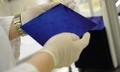 Un employé d’une entreprise allemande de cellules solaires tient une plaquette à base de silicium pour la production de cellules photovoltaïques, en Allemagne, le 2 juillet 2008. （Staff: BARBARA SAX / 2008 AFP）  