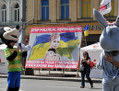 Le 8 Juin, à Kiev, quelques heures avant l’ouverture du tournoi, devant la zone réservée aux amateurs de l’Euro 2012, des fans posent devant des bannières appelant à la libération de l’ancien Premier ministre Ioulia Timochenko.（Stringer: GENYA SAVILOV / 2012 AFP）  