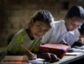 Une jeune fille prend des notes dans une école népalaise. （攝影:  / 大紀元）  