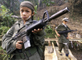 Les enfants du KNU (le Karen National Union), armée rebelle, tenant des armes d’assaut lors des célébrations marquant le 51e anniversaire de l’insurrection contre la junte à Tak, au niveau de la frontière thaïlandaise, qui s’est déroulée le 31 janvier 2000.（攝影: PORNCHAI KITTIWONGSAKUL / 大紀元）  