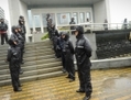 Des policiers montent la garde le 10 août, à l’extérieur du Tribunal intermédiaire du peuple de la ville de Hefei dans la province d’Anhui. Gu Kailai a été jugée  ici pour le meurtre de Neil Heywood, homme d’affaire britannique. (Peter Parks/AFP/GettyImages)