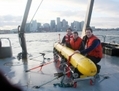 Les ingénieurs Emmett Gamroth, Alison Proctor, et Jeff Kennedy de l’Université du u00abVictoria’s Ocean Technology Lab» posent avec leur vaisseau sous-marin autonome. Les trois chercheurs participent aux efforts de l’Agence Parks Canada pour localiser les navires perdus de John Franklin’s. (UVic/Bluefin) 