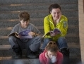 Une famille lisant le programme de Shen Yun à l’entracte de la représentation du dimanche 6 janvier à la Place des Arts. (Evan Ning/Époque Times)