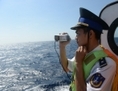 Cette photo a été prise le 14 mai 2014. Elle montre un garde-côte vietnamien prenant des photos d’un navire garde-côtes chinois près de la plate-forme de forage pétrolier dans un territoire maritime disputé en Mer de Chine du sud. (Hoang Dinh Nam/AFP/Getty Images)