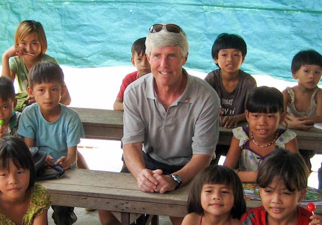 Le PDG d’Angkor Gold, Mike Weeks, est assis avec des enfants qui fréquentent une des écoles construites par sa compagnie au Cambodge. (Gracieuseté d’Angkor Gold) 