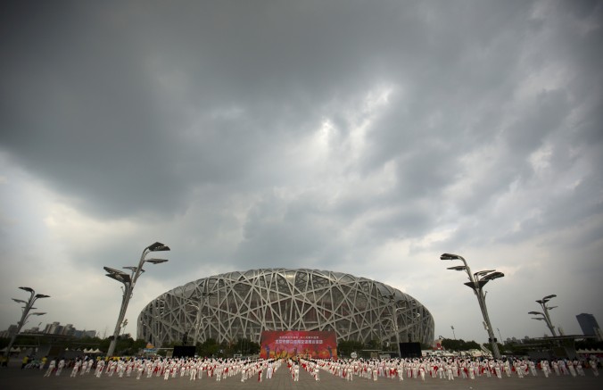 Des personnes célèbrent, devant l’Olympic Plaza, l’attribution des Jeux Olympiques d’Hiver 2022 à Pékin, le 31 Juillet 2015 à Beijing, Chine. (Xiaolu Chu/Getty Images)

