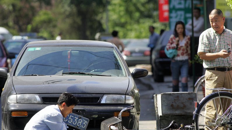 Un cycliste blessé secouru après avoir été renversé par une voiture à Pékin, en 2006. En raison de la multiplication des arnaques, les personnes désireuses de donner de l'aide doivent désormais recourir à une assurance. ( FREDERIC J. BROWN/AFP/Getty Images)
