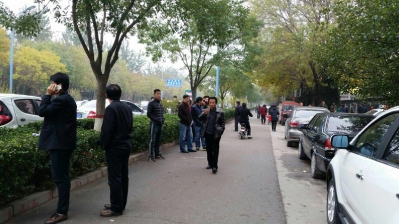 Des agents en civil encerclent un édifice de la cour à Cangzhou, Chine, le 9 novembre 2015. Neuf pratiquants de Falun Gong subissaient leur procès pour avoir tenu une rencontre. (Epoch Times)