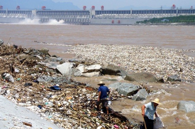 Deux ouvriers ramassent des déchets sur les rives du fleuve Yangzi, à proximité du barrage des Trois-Gorges. (STR/AFP/Getty Images)