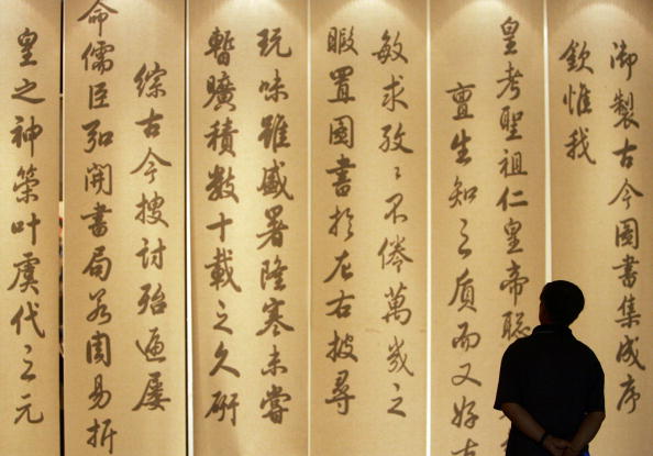 Un visiteur regarde d'anciennes calligraphies chinoises au Palais Wuying de la Cité Interdite le 27 août 2005 à Pékin en Chine. (China Photos/Getty Images)