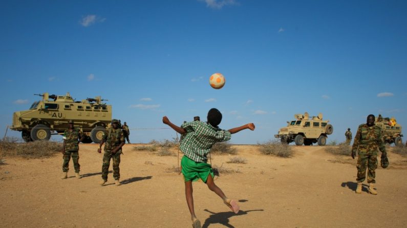 Des soldats ougandais de l’AMISOM jouent au football avec des enfants somaliens après avoir repris le contrôle d’une ville à Al-Shabab. (IRIN News)