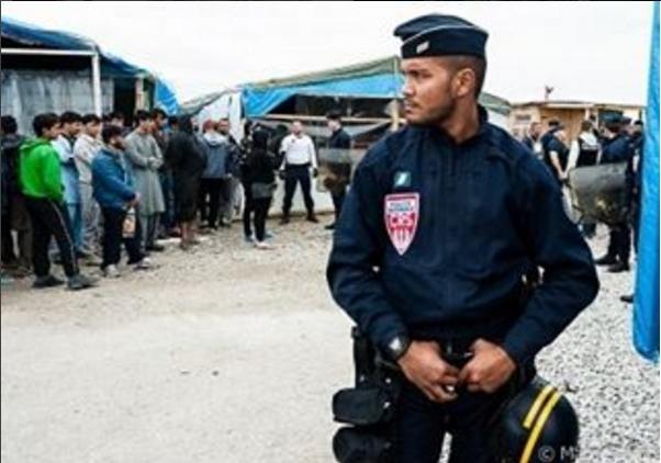 Un policier s’assure que les magasins et les restaurants sont fermés, conformément aux consignes données par les autorités. « La jungle » de Calais, Août 2016. (Instagram)