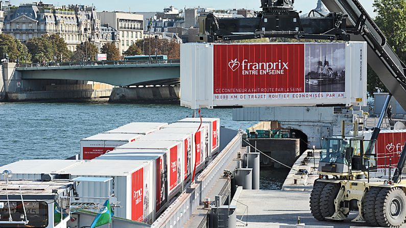 À Paris, il est courant de voir des containers Franprix transportés à bord de péniches sur la Seine. Depuis 2012, l’enseigne livre son alimentation par le fleuve à plus 80 points de vente dans le centre de Paris.  (ERIC PIERMONT/AFP/GettyImages)