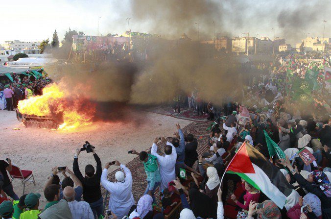 A Amman, la capitale de la Jordanie, les partisans des Frères musulmans mettent le feu à un faux tank israélien lors d'une manifestation célébrant la « victoire de Gaza » dans la guerre contre Israël. Photo du 8 août 2014. (KHALIL MAZRAAWI / AFP / Getty Images) 