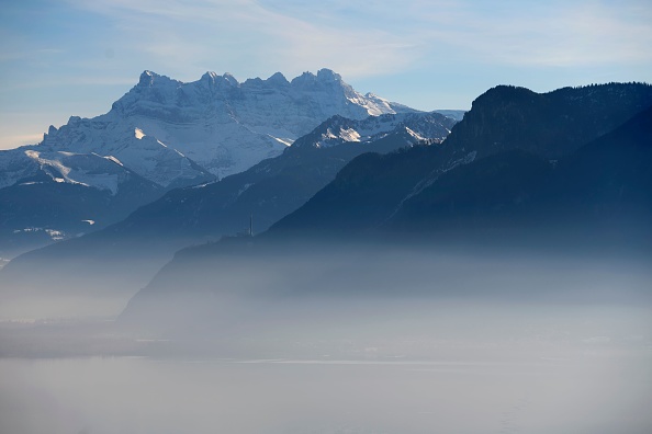 Une vue de Chardonne, en Suisse occidentale, montre une couche de smog sur le lac Léman face aux sommets des "Dents du Midi", dans les Alpes. (FABRICE COFFRINI/AFP/Getty Images)
