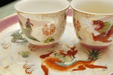 Une paire de tasses à thé à un mariage chinois exhibant le double caractère chinois du bonheur et les images du dragon mythique et du phénix, pour symboliser bonne fortune et un mariage heureux et harmonieux. (Voon Nam Fook/Photos.com)