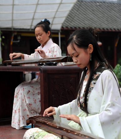 De jeunes femmes chinoises jouent le classique et complexe guqin, un parent de la famille des cithares. (China Photos/Getty Images)