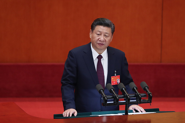  ​​Le président chinois Xi Jinping avec cravate rouge sur fond rouge. 
(Lintao Zhang/Getty Images)