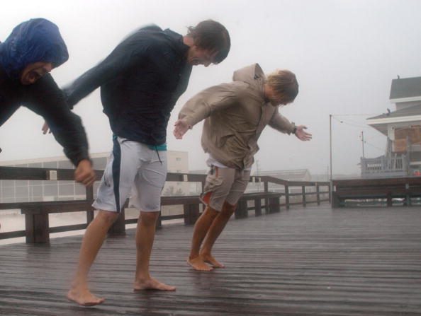 Des jeunes gens se penchent dans le vent en se tenant debout sur la jetée de l'Océanic dans les fortes pluies et les vents violents provoqués par l'ouragan Ophelia qui se termine sur la côte de la Caroline du Nord à Wrightsville en Caroline du Nord.
(Logan Mock-Bunting/Getty Images)