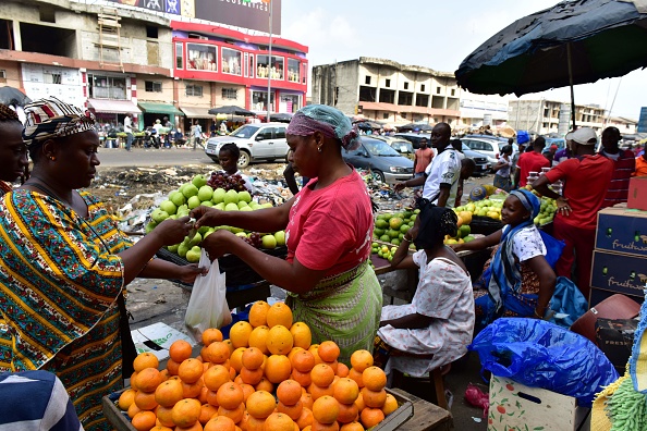 Un vendeur vend des fruits sur le grand marché d'Adjame, un quartier populaire d'Abidjan, le 10 août 2017. Le gouvernement ivoirien a annoncé, le 26 juillet, dans un conseil des ministres, le plafond des prix des aliments essentiels pour lutter contre le coût de la vie , tandis qu'une partie de la population se plaignait de ne pas ressentir les effets d'une forte croissance économique. 
(ISSOUF SANOGO / AFP / Getty Images)
