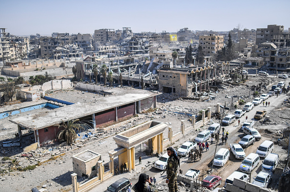 Un combattant des Forces démocratiques syriennes (FDS) pose alors que son camarade utilise un téléphone portable pour le photographier sur un toit à Raqa le 20 octobre 2017, après avoir repris la ville à des combattants du groupe État islamique (EI). Les combattants du FDS ont expulsé les résistants djihadistes de l'hôpital principal et du stade municipal de Raqa, complétant une offensive de plus de quatre mois contre ce qui était autrefois le sanctuaire du califat autoproclamé de l'EI, qui a connu pendant trois ans les pires abus du groupe. (BULENT KILIC / AFP / Getty Images)

