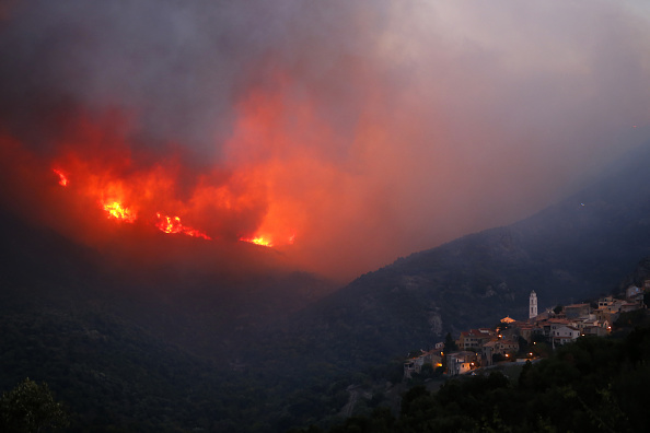 Le feu engloutit les collines près du village de Palasca en Corse le 22 octobre 2017. Les feux qui ont pris feu vers 09h00 le 22 octobre, dans la municipalité de Ville-di-Paraso (Haute-Corse) ont brûlé quelque 500 hectares et continuent d'être alimentés par de forts vents du sud-ouest qui se propagent aux villages de Costa, Occhiatana, Novella et Palasca. (PASCAL POCHARD-CASABIANCA / AFP / Getty Images)