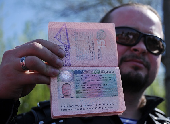 Un membre du Russian Night Wolves Motorcycle Club montre son passeport avec son visa annulé à un poste frontalier avec la Pologne. 
(SERGEI GAPON / AFP / Getty Images)