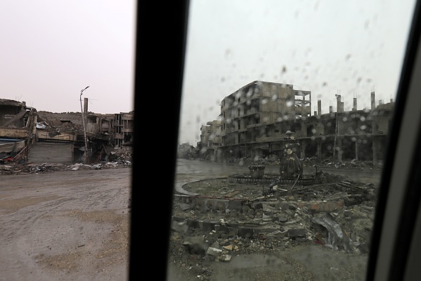Une photo prise le 28 octobre 2017 montre une vue de bâtiments endommagés dans la ville syrienne de Raqa. Le SDF, soutenu par les Etats-Unis, a pris le contrôle total de Raqa le 17 octobre, concluant une opération qui a duré plus de quatre mois pour capturer une ville qui avait été le sanctuaire du "califat" moribond de l'EI. Des centaines de milliers de personnes ont fui la ville depuis 2014 et au moment où le SDF l'a repris, Raqa était devenue une ville fantôme de bâtiments effondrés. 
(DELIL SOULEIMAN / AFP / Getty Images)