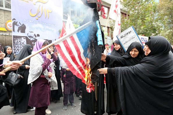 Des Iraniennes brûlent un drapeau américain  devant l'ancienne ambassade américaine à Téhéran, la capitale iranienne, le 4 novembre 2017.
(ATTA KENARE / AFP / Getty Images)