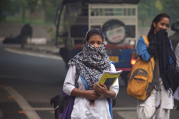 Une jeune Indienne au visage couvert se promène dans un grand brouillard dans une rue de New Delhi le 13 novembre 2017. Les écoles ont rouvert à New Delhi le 13 novembre malgré un nouveau pic de pollution aux niveaux d'urgence, provoquant des protestations de parents dans la capitale indienne. a déclaré que le déplacement des enfants les mettait en péril. 
(DOMINIQUE FAGET / AFP / Getty Images)