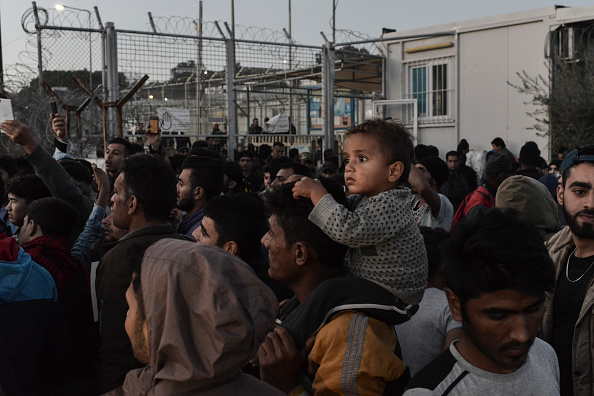 Un homme tient un enfant sur ses épaules tandis que des réfugiés et des manifestants protestent contre leur "détention".
(ARIS MESSINIS / AFP / Getty Images)