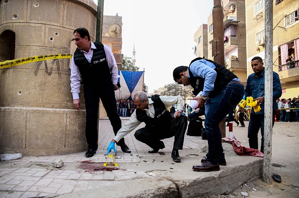 Des membres égyptiens de la sécurité et de la police judiciaire inspectent le site d'une attaque à l'arme à feu devant une église au sud de la capitale, le 29 décembre 2017. Un tireur a ouvert le feu sur une église, tuant au moins neuf personnes. 
(SAMER ABDALLAH / AFP / Getty Images)

