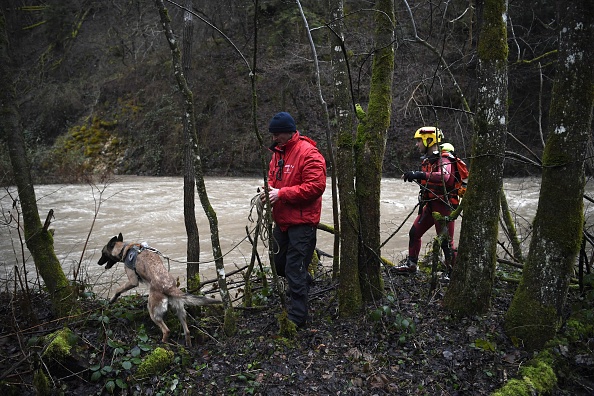 Une équipe de secours recherche avec un chien sur les rives de la rivière Breda le pompier volontaire porté disparu après une intervention le 4 janvier 2018 lors de la tempête Eleanor à Detrier près de Pontcharra, dans la région Rhône-Alpes, sud-est de la France. (PHILIPPE DESMAZES/AFP/Getty Images)
