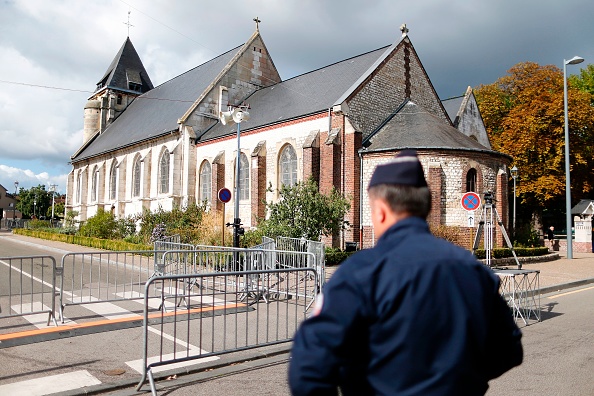 Un officier de police se tient à l'extérieur de l'église Saint-Etienne-du-Rouvray le 2 octobre 2016. Deux mois après que son prêtre a été assassiné par des jeunes djihadistes, les paroissiens d'une église catholique dans le nord de la France se sont réunis le 2 octobre pour une cérémonie de réouverture solennelle pour chercher réconfort et solidarité. 
(CHARLY TRIBALLEAU / AFP / Getty Images)
