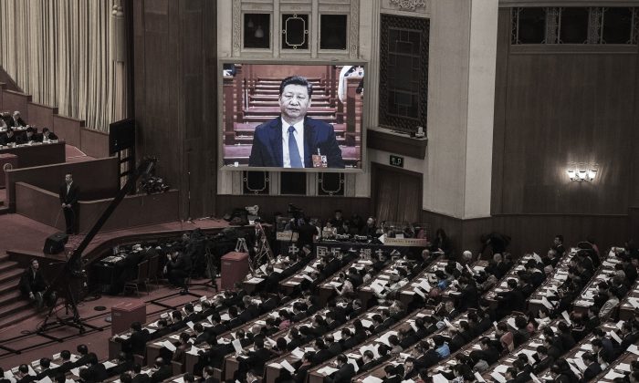 L’image de dirigeant chinois Xi Jinping, retransmise sur un grand écran, surplombe les délégués de l’Assemblée nationale populaire réunis au Grand palais du Peuple à Pékin, le 11 mars 2018. (Kevin Frayer/Getty Images)