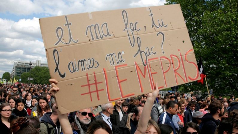 Les gens tiennent une pancarte en lisant un message inspiré d'une célèbre citation du film Le Mépris de Jean-Luc Godard "Et mon université, vous aimez mon université ?" GEOFFROY VAN DER HASSELT / AFP / Getty Images