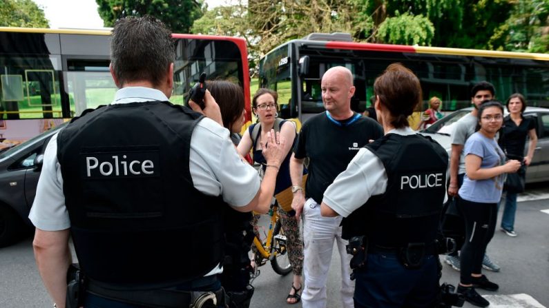 Un policier s'entretient avec des parents d'enfants dans un lycée voisin de Liège, le 29 mai 2018, après qu'un homme armé ait abattu trois personnes, dont deux policiers, avant d'être tué par des officiers d'élite. Photo JOHN THYS / AFP / Getty Images