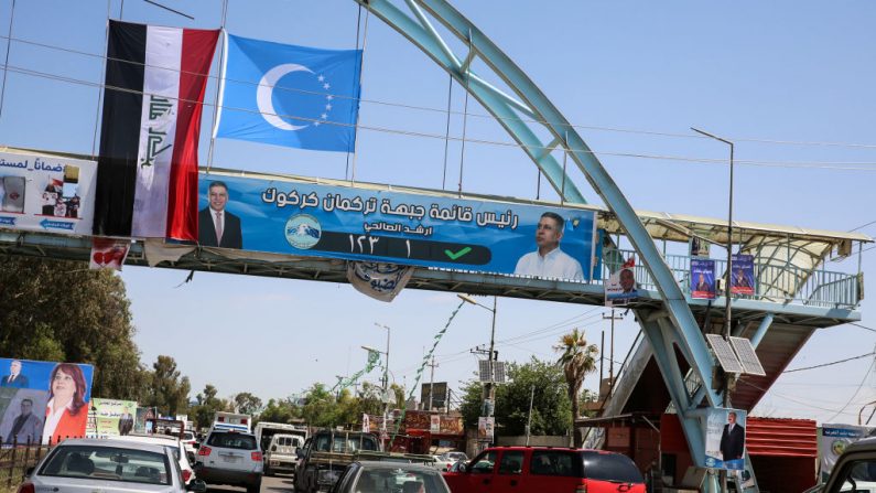 Une photo prise le 30 avril 2018 montre une bannière électorale pour le Front turkmène irakien suspendu sous les drapeaux de l’Irak et des Turkmènes irakiens, croissant blanc et étoiles sur fond bleu. Photo SABAH ARAR / AFP / Getty Images.
