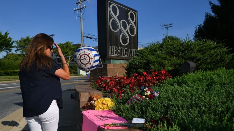  Une femme se croise après avoir déposé des fleurs à un mémorial improvisé près des bureaux du journal Capital Gazette à Annapolis le 29 juin 2018.   Photo MANDEL NGAN/AFP/Getty Images;