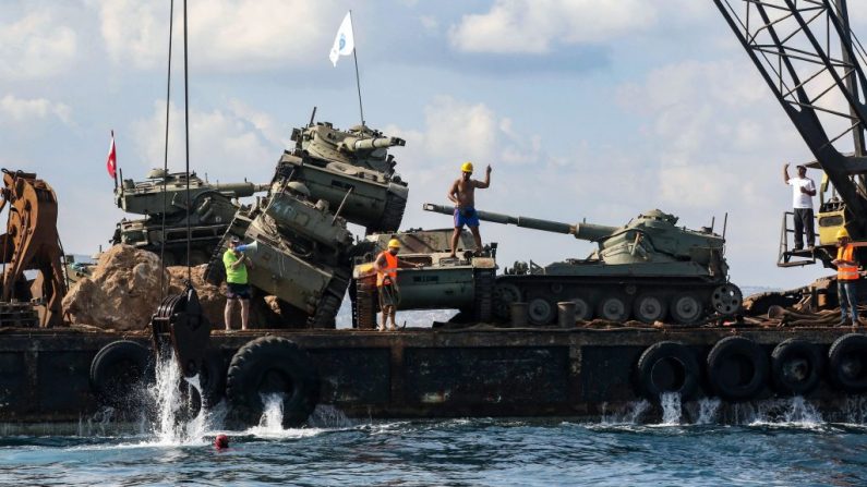 Des militants écologistes déposent de vieux chars de combat fournis par les Forces armées libanaises dans la mer Méditerranée, à environ trois kilomètres au large de la ville portuaire de Sidon, au sud du Liban, le 28 juillet 2018, pour créer un nouvel habitat pour la vie marine. Photo MAHMOUD ZAYYAT / AFP / Getty Images.