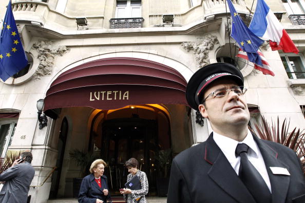 Un groom se tient devant l'entrée de l'hôtel Lutetia à Paris. Ouvert par les propriétaires du grand magasin voisin Bon Marché, l'hôtel Art déco célèbre cette année son centenaire. Photo PATRICK KOVARIK / AFP / Getty Images.